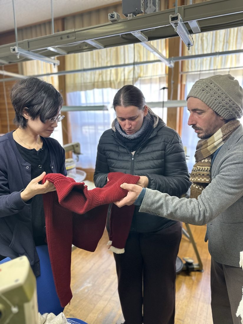工場見学でカシミヤ製品を手に取るフランスからのゲスト